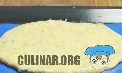 Кладем пирог на поддон, смазываем яйцом и посыпаем мелко тертым сыром.