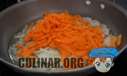 Нарезаем две моркови тонкой стружкой и отправляем морковку на сковородку к луку.