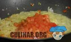 Перекладываем в сковороду нарезанный помидор, перемешиваем и готовим 5-6 минут.