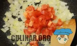 Нарезаем маленькими кубиками помидор и отправляем томаты на сковородку к луку. Хорошо перемешиваем.