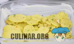 Форму для запекания смазываем сливочным маслом и выкладываем 1/2 часть картофеля.
