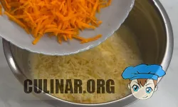 Натираем морковь на крупной терке и твердый сыр. Перекладываем в яичную массу и перемешиваем.