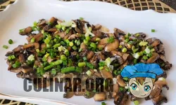 Жареные грибочки выкладываем равномерно на блюде и посыпаем измельченным зеленым луком.